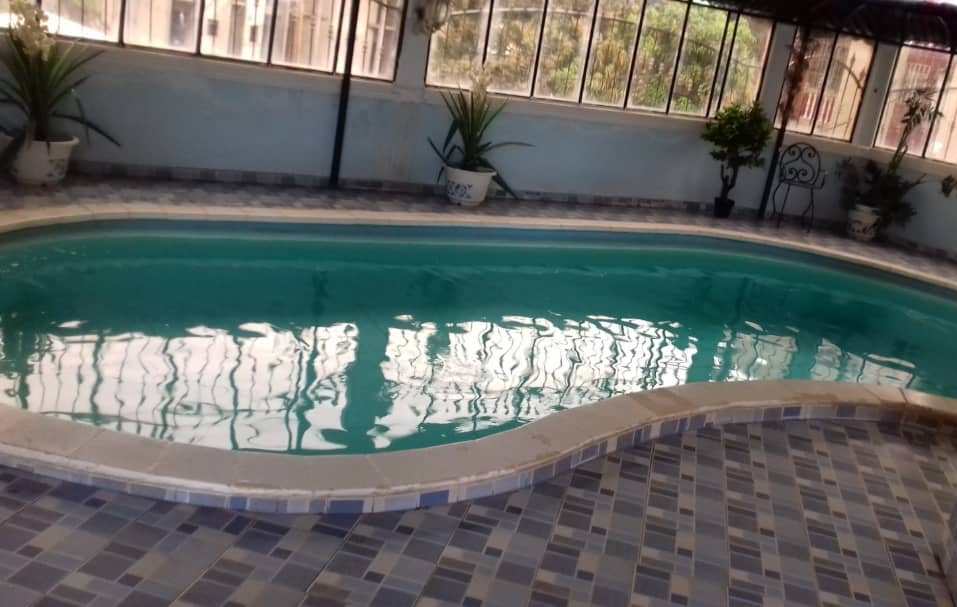 Photo d'une piscine extérieure dans un immeuble moderne, avec vue sur un appartement meublé de luxe à Bastos, Yaoundé.