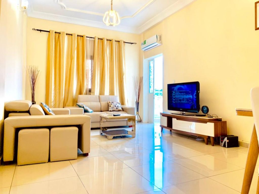 : Photo d'un salon luxueux avec des chaises en cuir épais et un éclairage tamisé dans l'appartement "Sky Home" à Yaoundé.